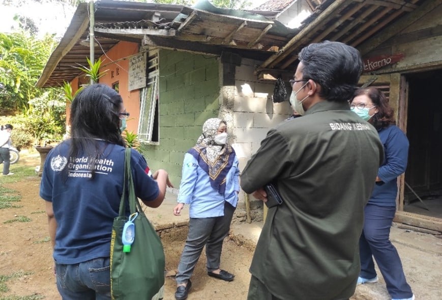 Four people discussing in front of a building.